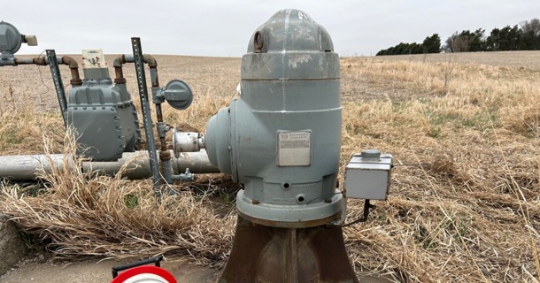 : A well measuring tape is positioned next to an irrigation well head in preparation for making a water level measurement.