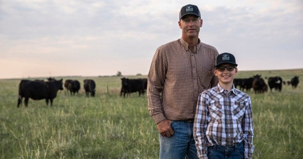 Nebraska producer Troy Anderson (left) stands with his son in a pasture on their operation, where Beef Quality Assurance principles guide daily decisions around herd health, handling and overall cattle care. Image courtesy of Certified Angus Beef.