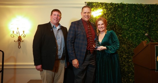 Brett Forsman, GISH Construction Pathway Teacher, Matt Fisher, GIPS Superintendent, and Lindsey Jurgens, Grand Island Area Habitat for Humanity, smiling with Business Partner of the Year Award