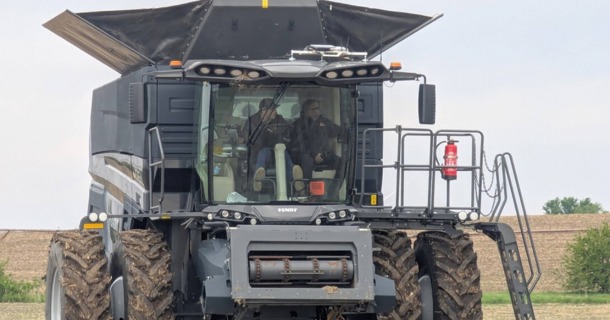 Santosh Pitla (right), professor of biological systems engineering, rides in a tractor at the grand opening of PTx Trimble's facility in Seward last spring. (Courtesy)