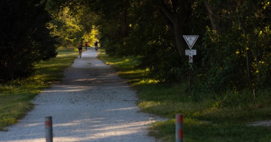 : Runners and a cyclist share the MoPac East Trail near Walton, Nebraska, on Sept. 10. (Liz McCue/University Communication and Marketing)